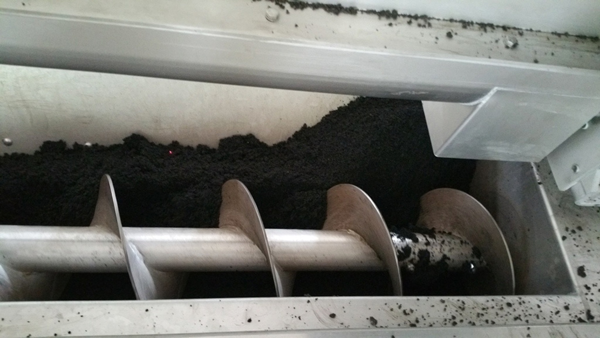 Feeding system: feeding screw controlled by level sensors (red dot) – Courtesy of Eliquo Stulz